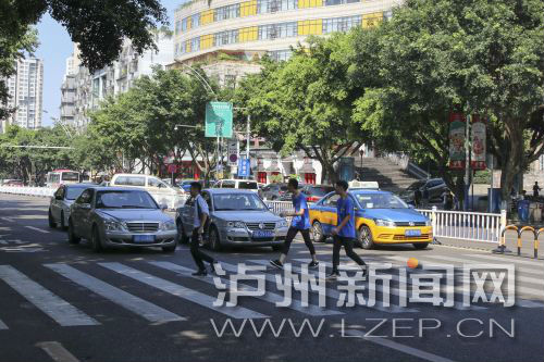 四川警察學(xué)院前的斑馬線沒有紅綠燈，但過往車輛見到有行人過斑馬線都會(huì)禮讓行人